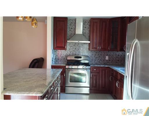 33 Woodbury Road Edison, NJ 08820 - Photo 5 of 11 a kitchen with stainless steel appliances granite countertop a refrigerator a stove and a sink