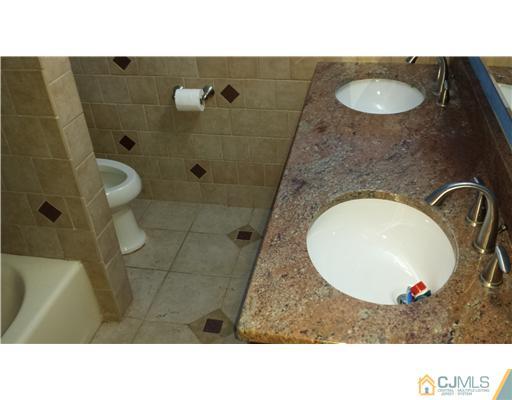 33 Woodbury Road Edison, NJ 08820 - Photo 7 of 11 a bathroom with a sink a toilet and shower