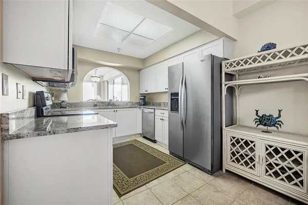 a kitchen with stainless steel appliances granite countertop a refrigerator a sink and a stove