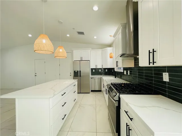 a kitchen with granite countertop a white sink cabinets and stainless steel appliances