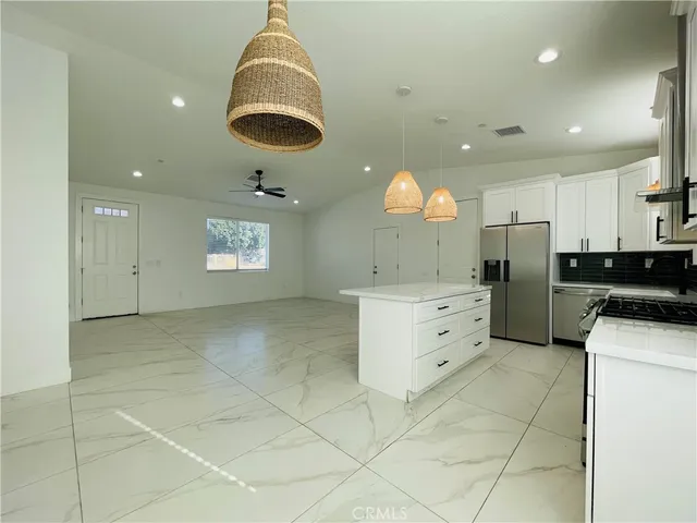 a kitchen with stainless steel appliances granite countertop a stove a sink and a refrigerator