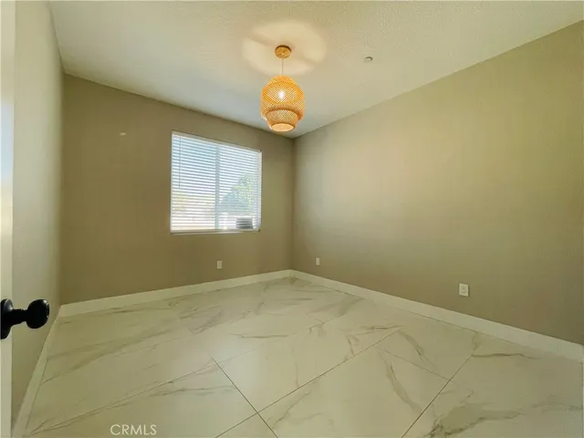 an empty room with a mirror and a fan