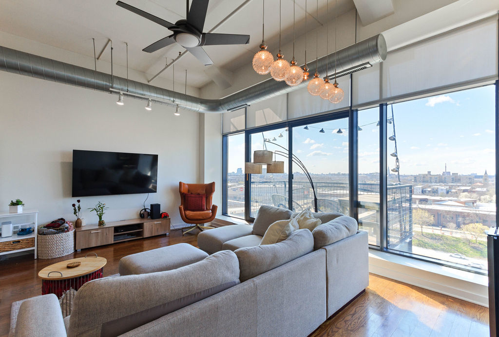 1224 West Van Buren Street, Unit 707 Chicago, IL 60607 - Photo 3 of 15 a living room with furniture a ceiling fan and a flat screen tv