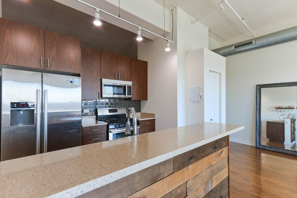 1224 West Van Buren Street, Unit 707 Chicago, IL 60607 - Photo 6 of 15 a kitchen with granite countertop a refrigerator and a sink