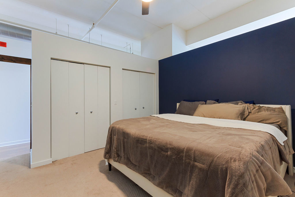 1224 West Van Buren Street, Unit 707 Chicago, IL 60607 - Photo 10 of 15 a bedroom with a bed and a lamp
