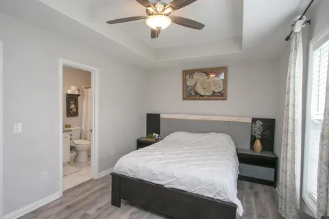 a bedroom with a large bed and a chandelier