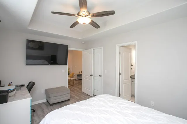 a spacious bedroom with a bed and a flat screen tv