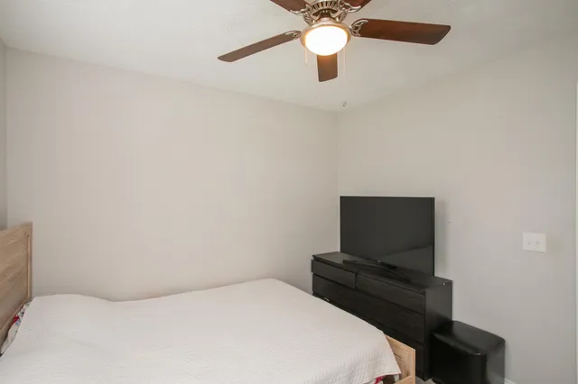 a bedroom with a bed and a flat tv screen on a table