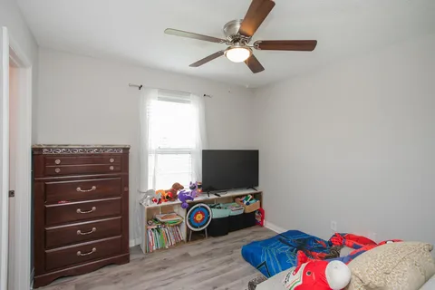 a bedroom with a bed window and a dresser