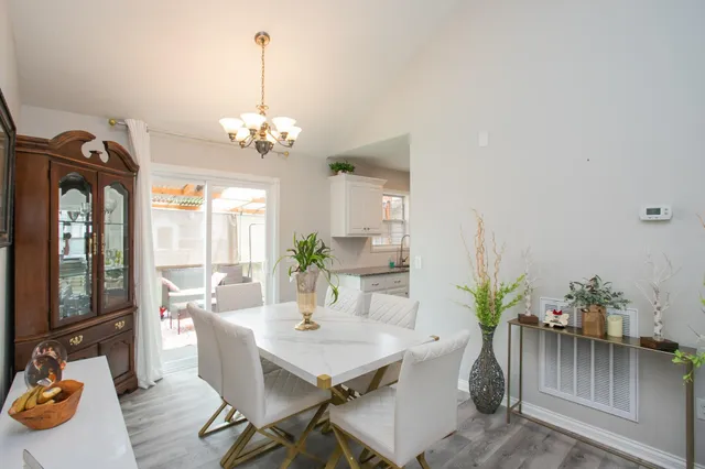 a view of a dining room with furniture a livingroom and chandelier