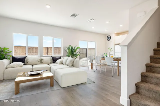 a living room with furniture potted plant and a mirror