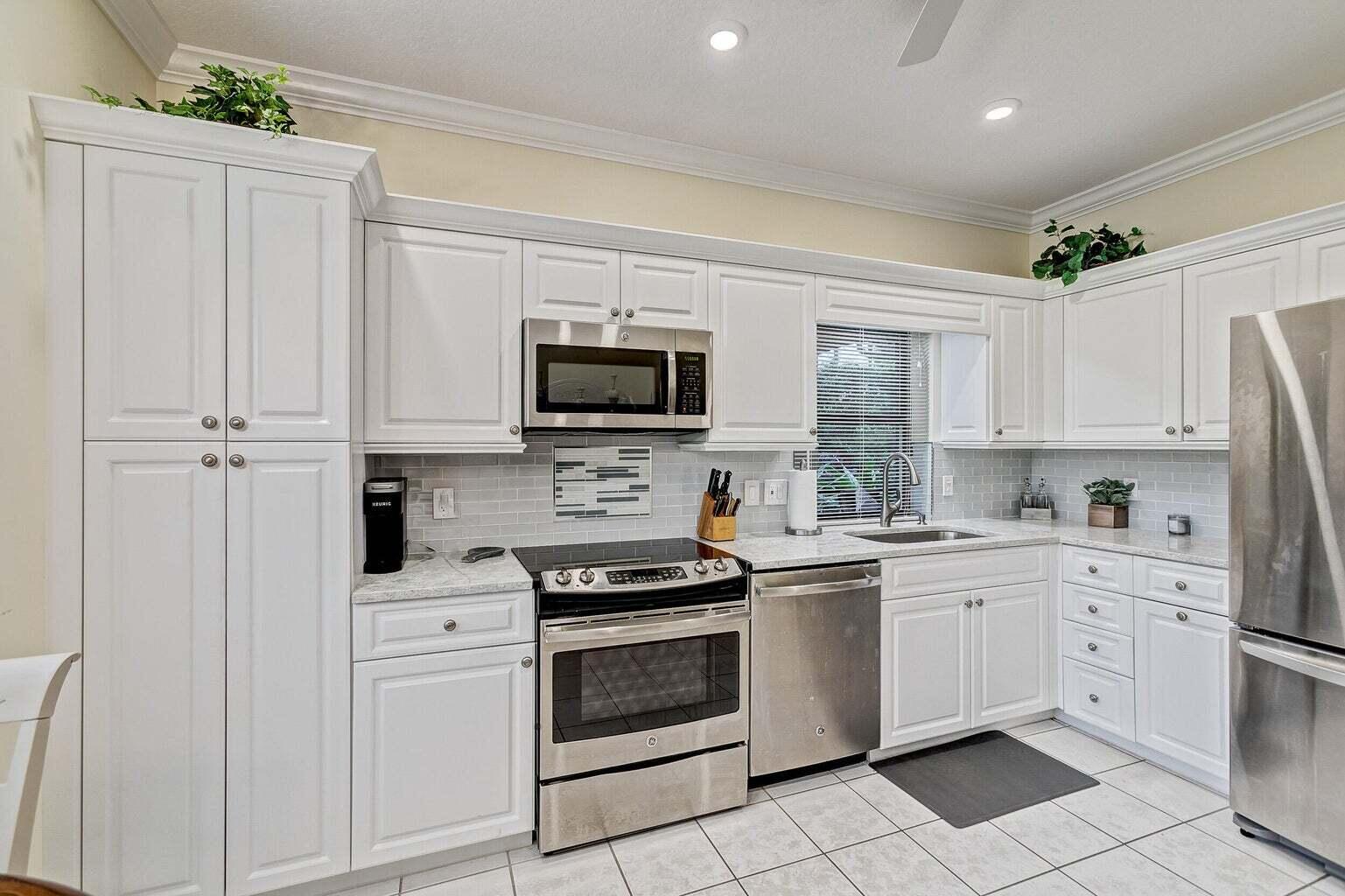 a kitchen with white cabinets and white appliances