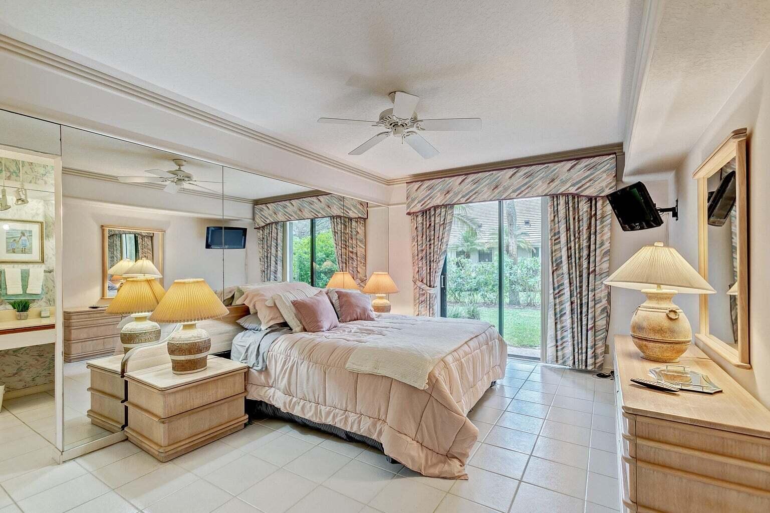 16151 West Bay Drive, Unit 161 Jupiter, FL 33477 - Photo 8 of 19 a spacious bedroom with a bed and a window
