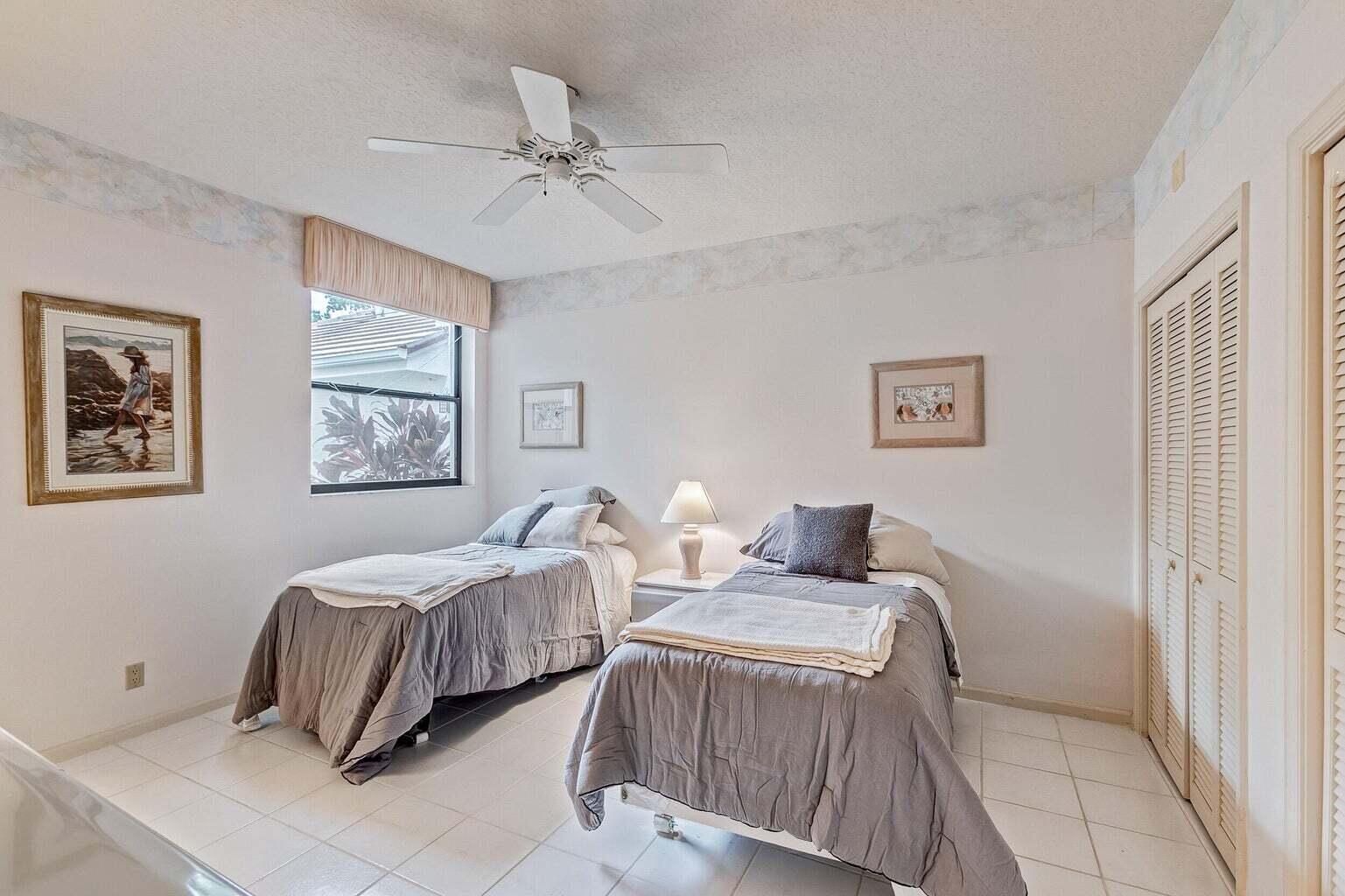 16151 West Bay Drive, Unit 161 Jupiter, FL 33477 - Photo 10 of 19 a bedroom with two beds and painting on the wall