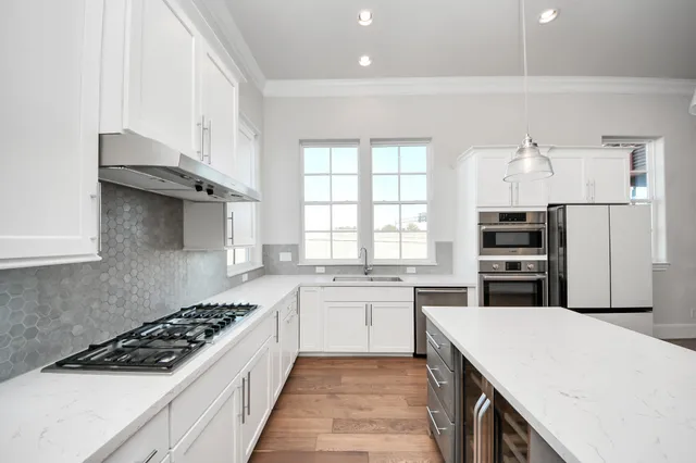 a kitchen with stainless steel appliances a refrigerator sink and stove