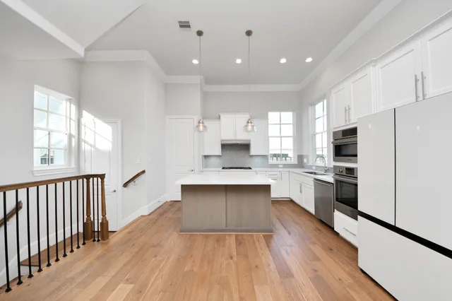 a large kitchen with cabinets wooden floor and stainless steel appliances