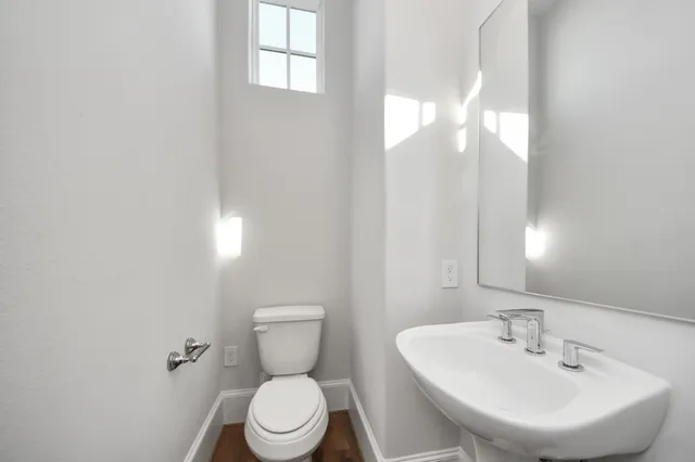 a bathroom with a toilet a sink and mirror