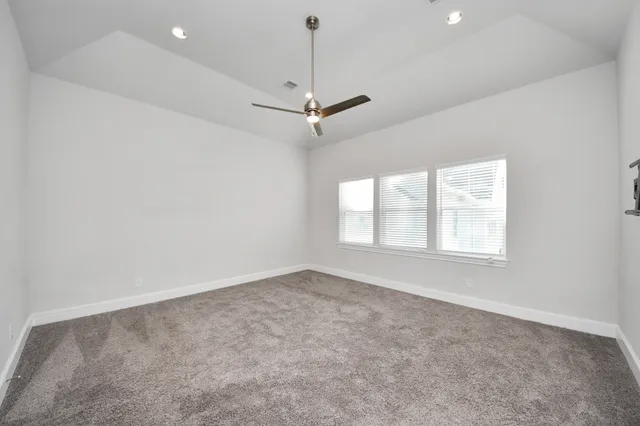 an empty room with a window and a fan