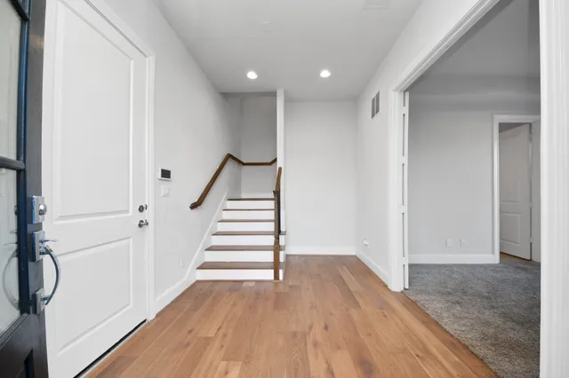 a view of a hallway with wooden floor and entryway