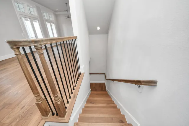 a view of a hallway with wooden floor and staircase