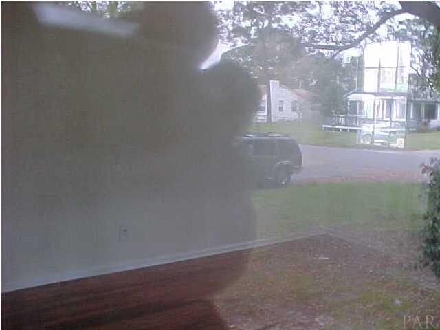 301 Payne Road Pensacola, FL 32507 - Photo 3 of 9 an empty room with wooden floor and windows