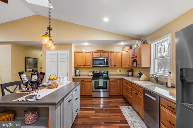a large kitchen with stainless steel appliances granite countertop a sink stove and refrigerator