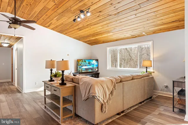 a living room with furniture a flat screen tv and a large window