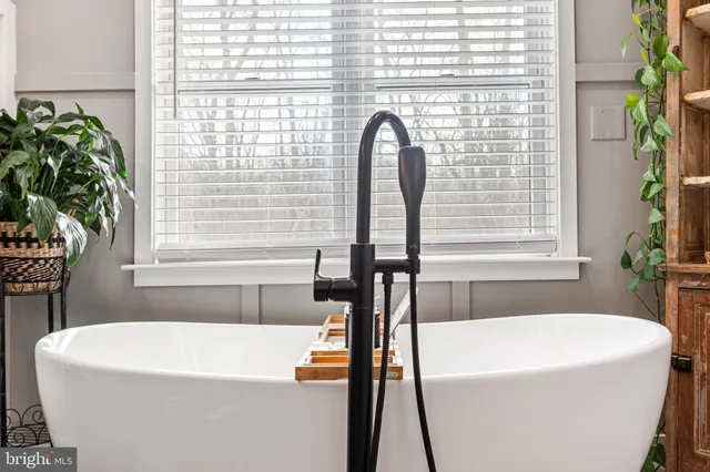 a white bath tub sitting in a bathroom next to a window