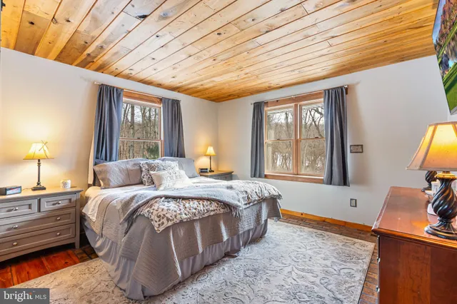 a bed room with a bed and a dresser next to a window