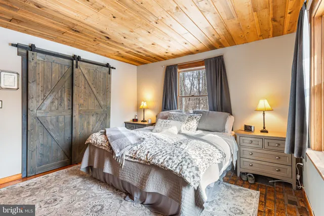 a bedroom with a bed lamp and a large window