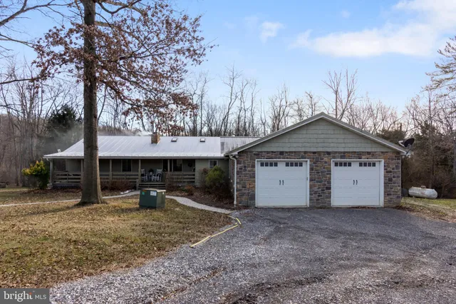 a view of a house with a yard and large tree