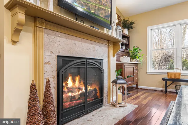 a living room with a fireplace furniture a dining table and wooden floor