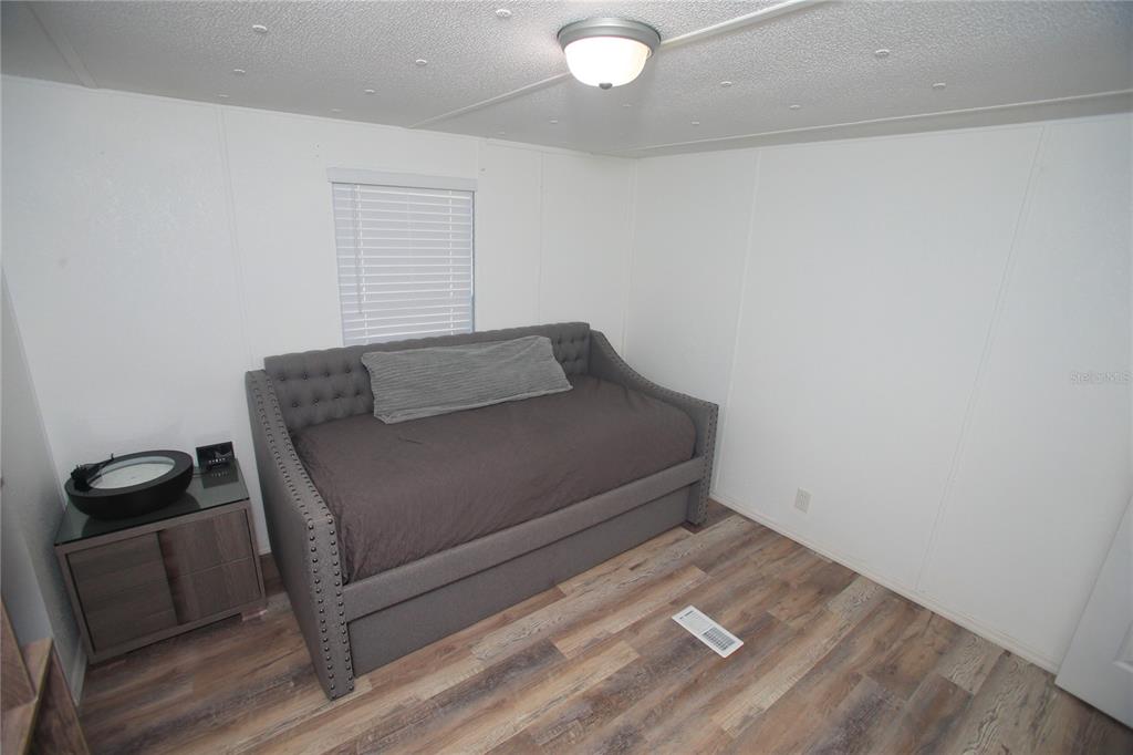 131 Southwest 76th Terrace Ocala, FL 34474 - Photo 22 of 27 a room with a chair and wooden floor