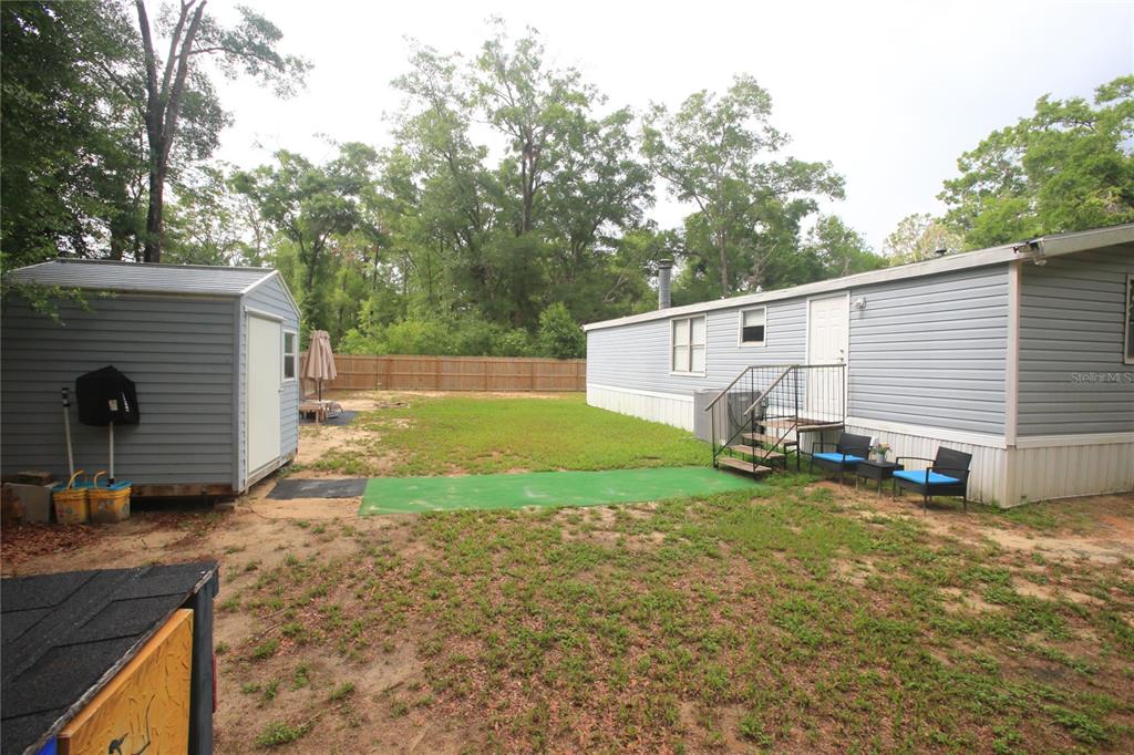 131 Southwest 76th Terrace Ocala, FL 34474 - Photo 5 of 27 a view of a backyard with a house and a large tree