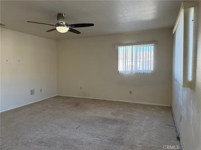 an empty room with closet and a ceiling fan