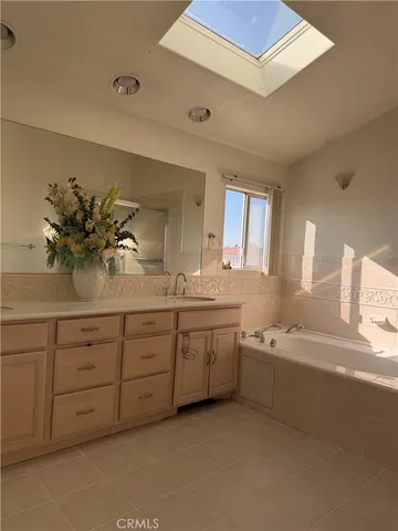 a spacious bathroom with a granite countertop sink mirror and bathtub