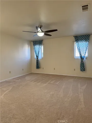 a view of an empty room and a ceiling fan