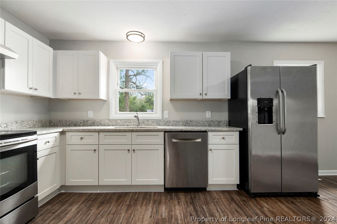 1604 Shaw Road Fayetteville, NC 28311 - Photo 11 of 30 a kitchen with stainless steel appliances granite countertop a refrigerator sink and white cabinets