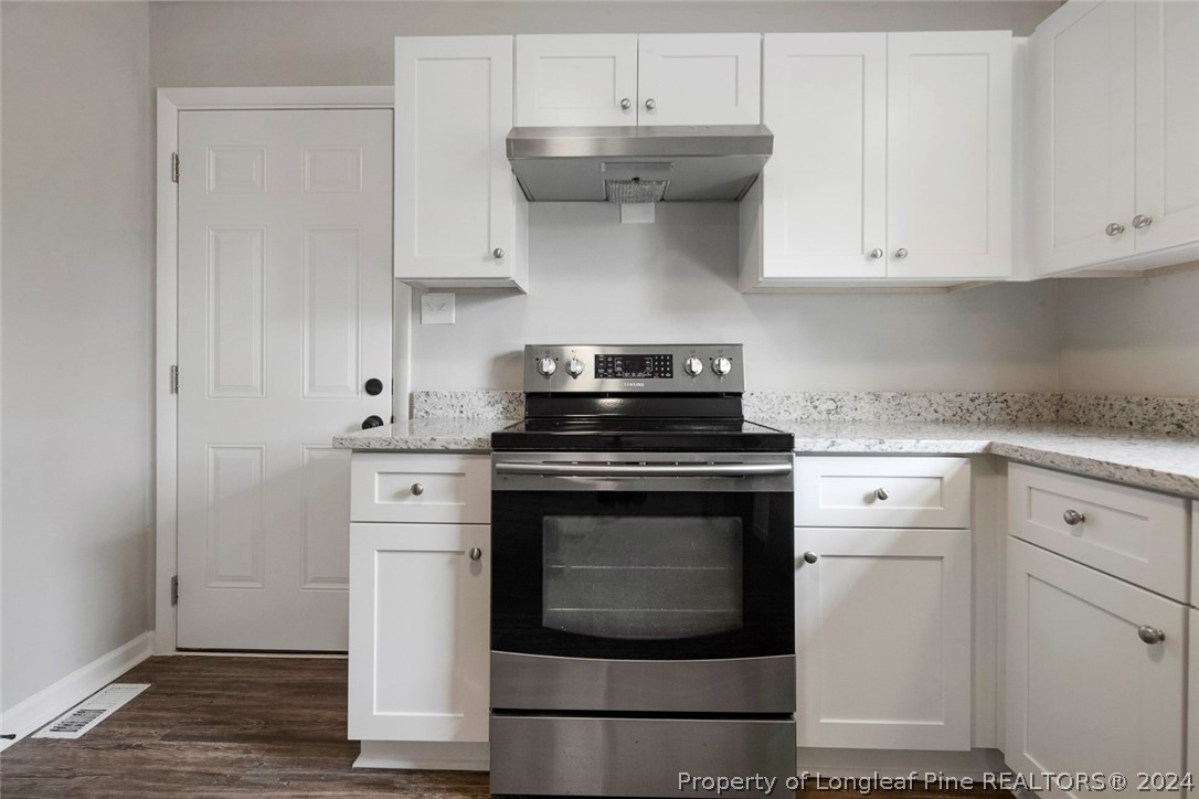 1604 Shaw Road Fayetteville, NC 28311 - Photo 13 of 30 a kitchen with stainless steel appliances granite countertop a stove a sink and a white cabinets