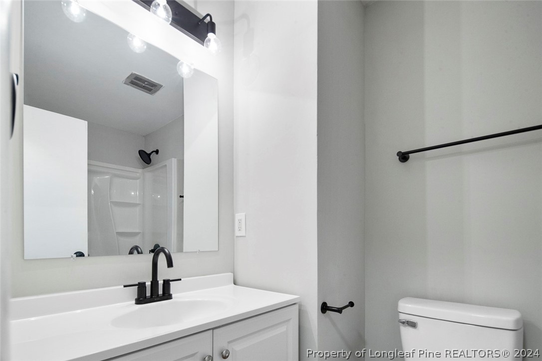 1604 Shaw Road Fayetteville, NC 28311 - Photo 15 of 30 a bathroom with a sink a toilet a mirror and shower