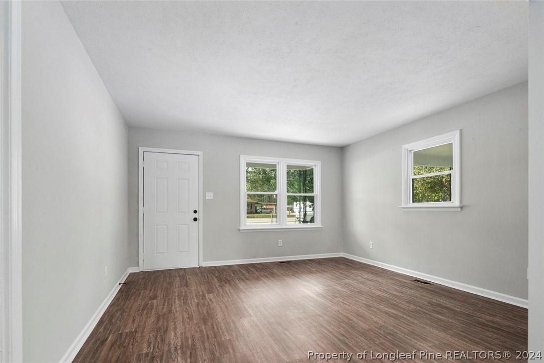1604 Shaw Road Fayetteville, NC 28311 - Photo 6 of 30 an empty room with wooden floor and windows