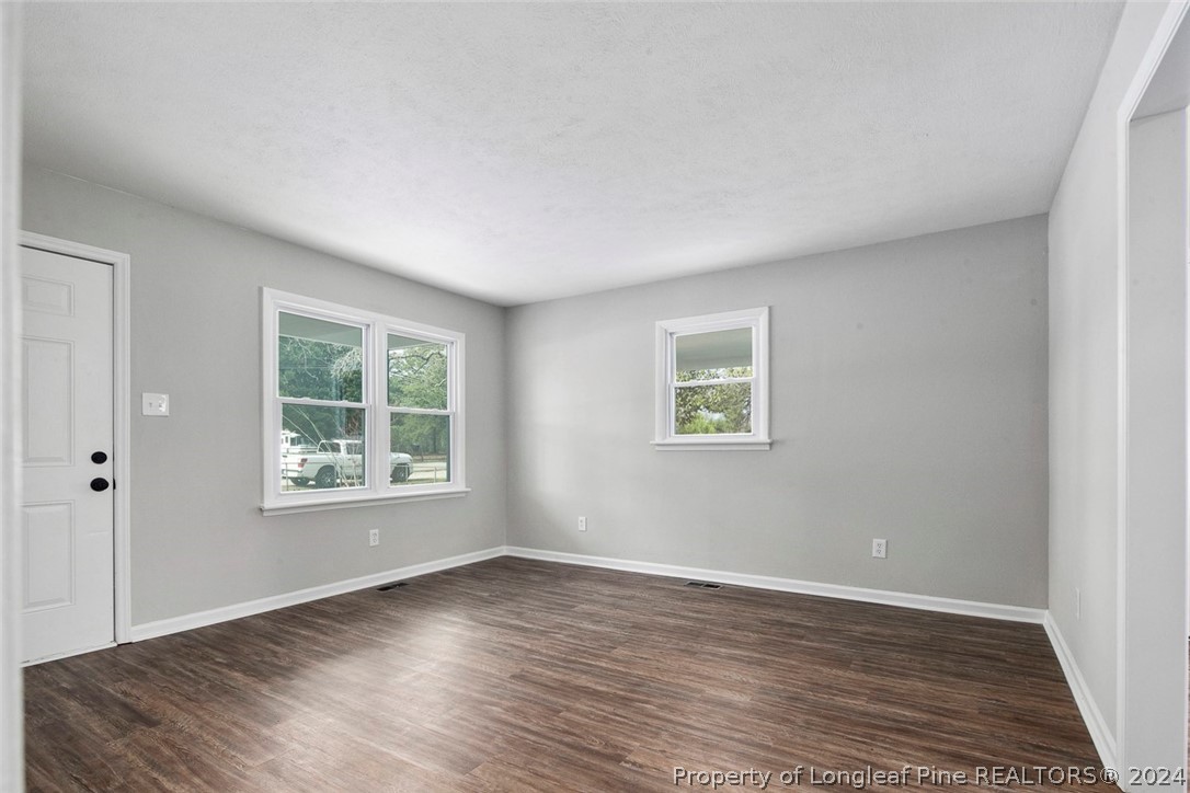 1604 Shaw Road Fayetteville, NC 28311 - Photo 7 of 30 an empty room with wooden floor and windows