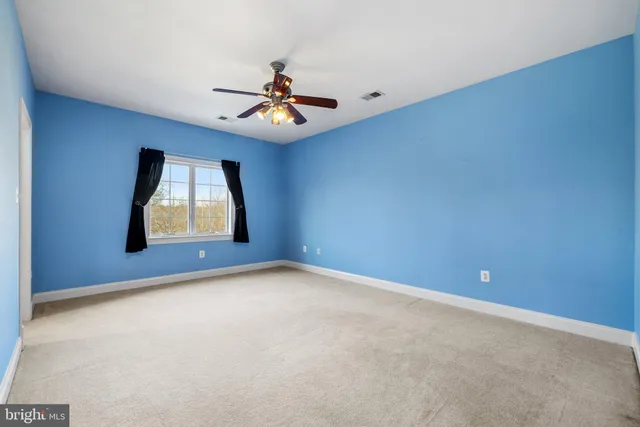 a view of a livingroom with a ceiling fan and window