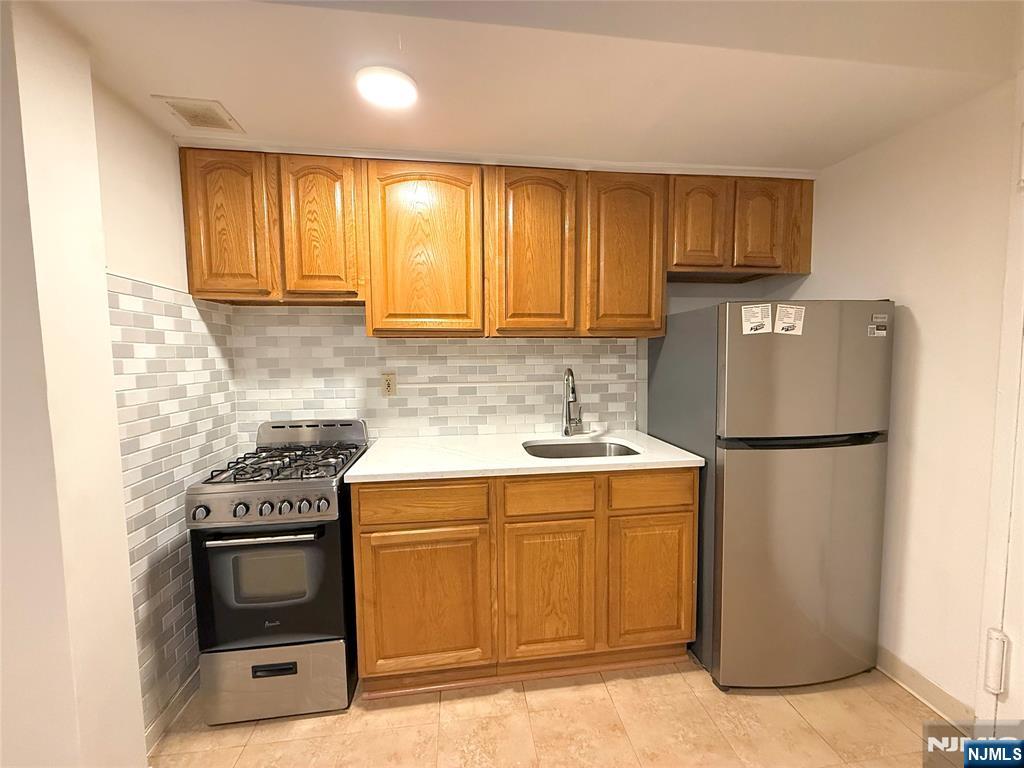 3091 Edwin Avenue, Unit 3D Fort Lee, NJ 07024 - Photo 2 of 11 a kitchen with a stove a sink and a refrigerator