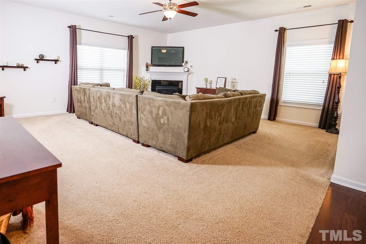 Large carpeted family room with gas fireplace and plenty of natural light.  Chase pipe in living room to help hide TV wires
