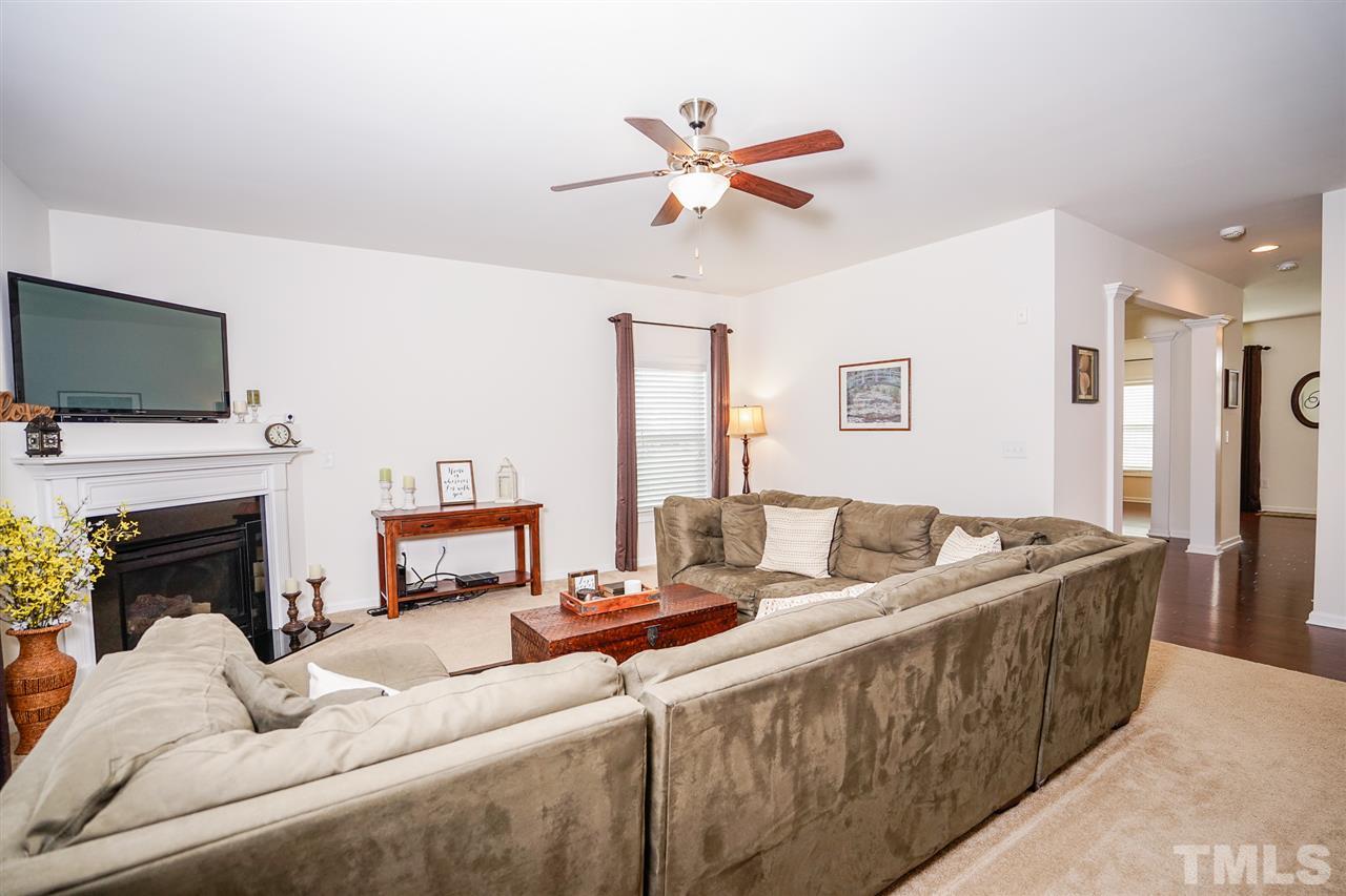 Large family room features a fireplace, carpeted floor and easy connection to kitchen and dining areas.  Full featured home security system with video and smart lighting integration