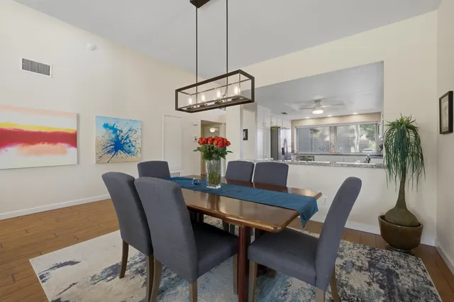 a dining room with furniture potted plants and wooden floor