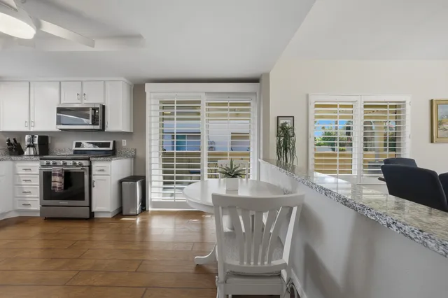 a kitchen with kitchen island a large window a sink and stainless steel appliances