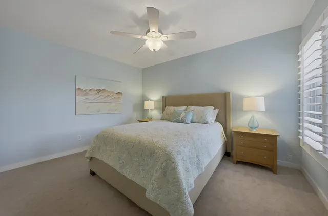 a spacious bedroom with a bed and a chandelier