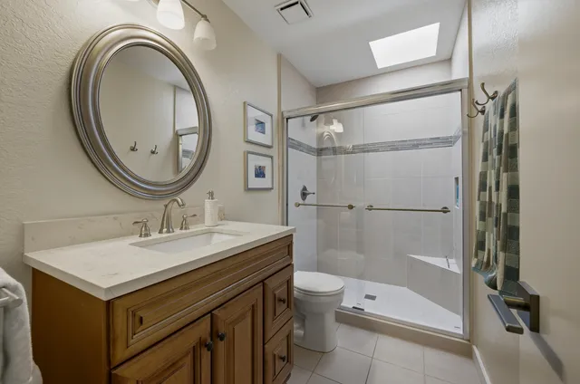 a bathroom with a sink a toilet and a mirror